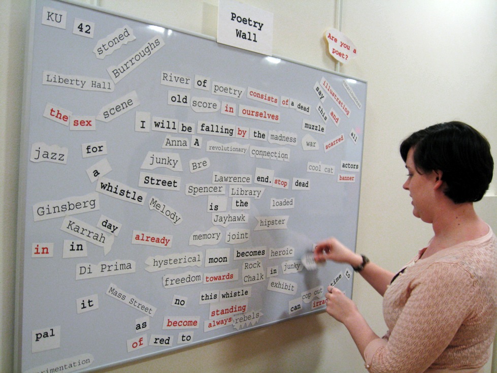 Photograph of exhbiition visitor at the magnetic poetry wall.