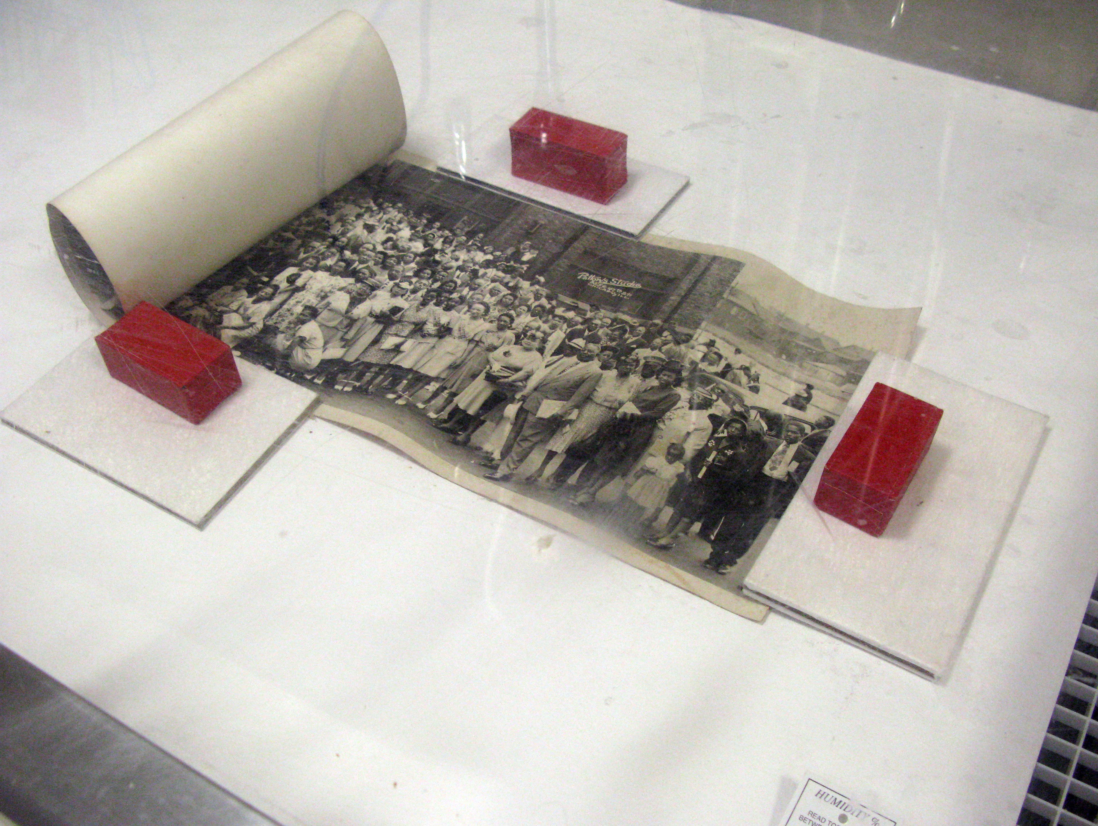 Image of unrolling a humidified photograph.