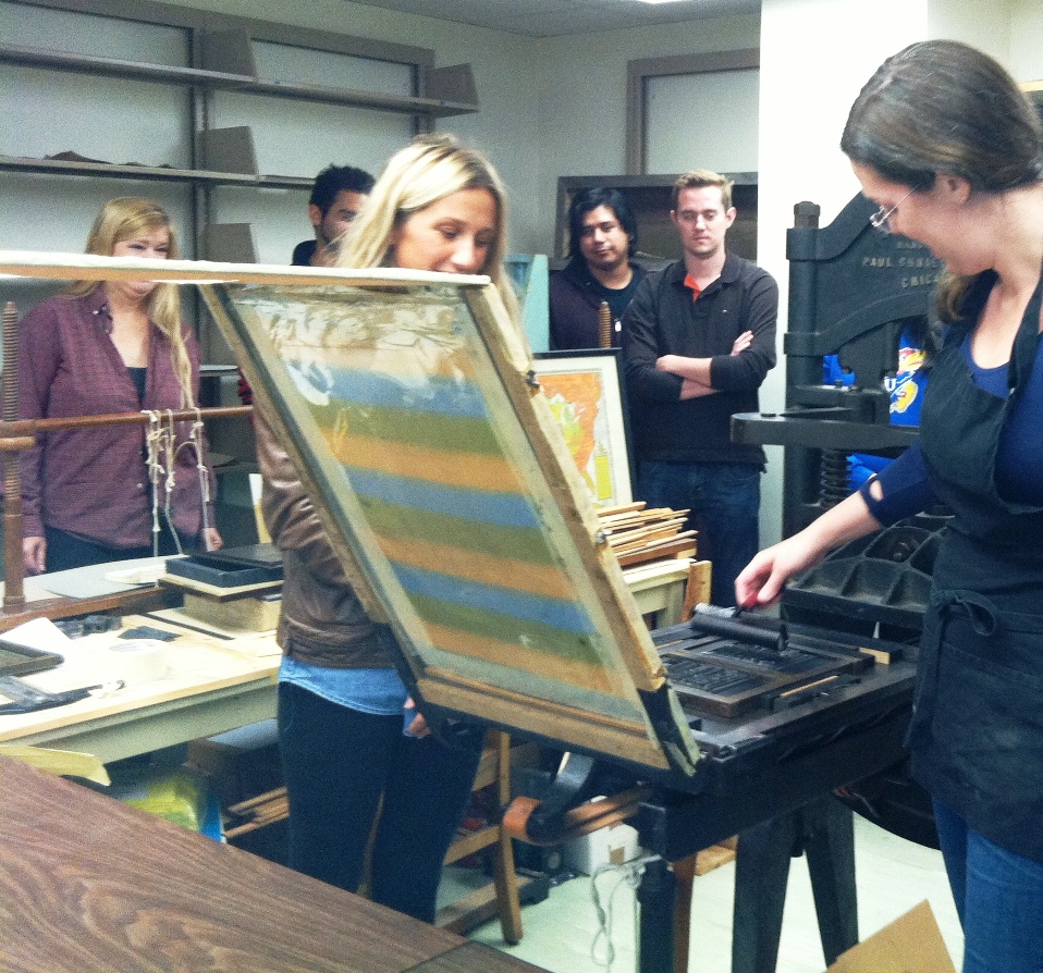 Students hand-inking the type using a brayer.