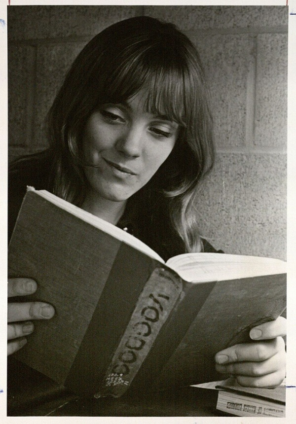 Photograph of a female KU student reading book about voodoo, 1970