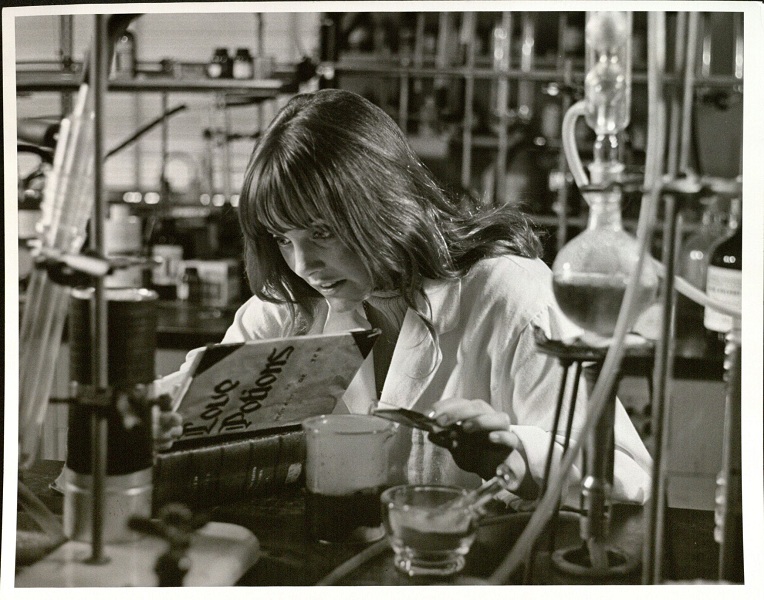 Photograph of a female KU student mixing a love potion, 1970