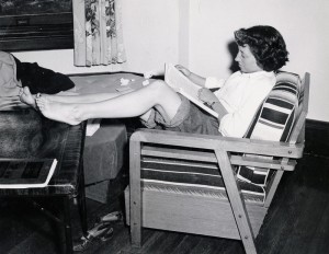 Photograph of student studying with bare feet, 1950s. 