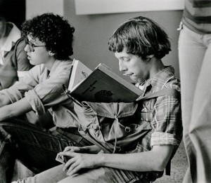 Photograph of student studying on top of backpack, 1976-1977.