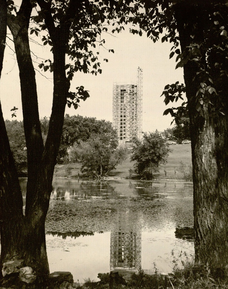 Photograph of the campanile under construction from across Potter Lake, 1950