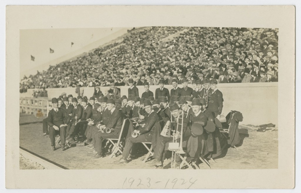 Photograph of the KU Marching Band sitting on the sidelines at a football game, 1924-1925