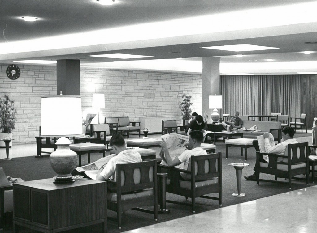 Photograph of McCollum Hall residents reading newspapers in the main lounge, 1965