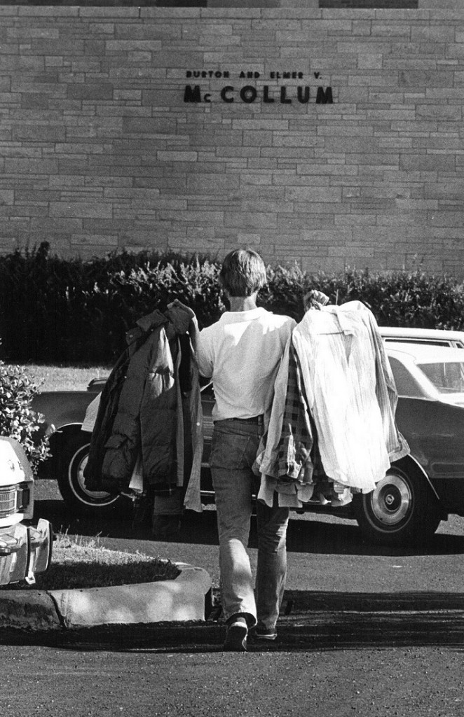 Photograph of a student carrying clothes into McCollum Hall, 1978/1979