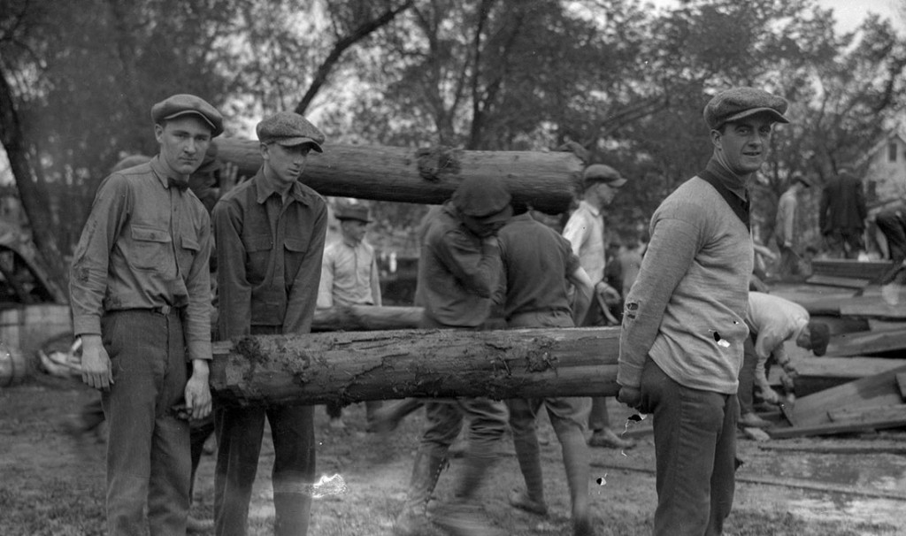Photograph of Stadium Day, men carrying logs, 1921