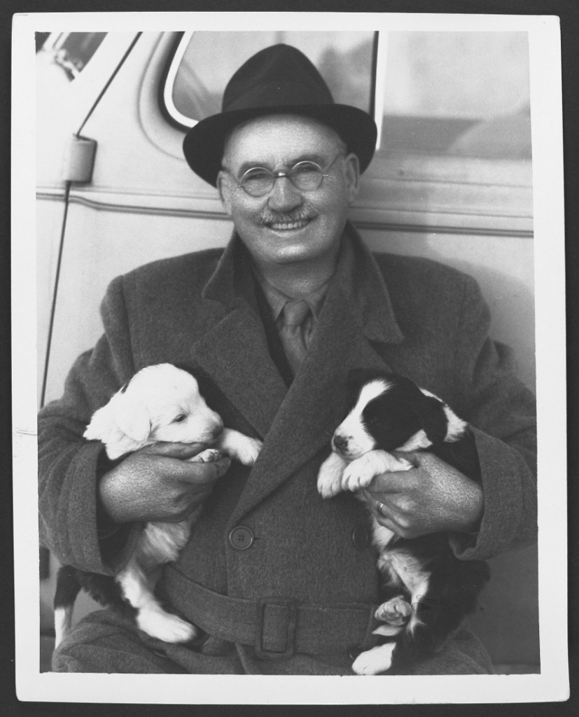 Photograph of Dr. James Naismith with two puppies during a trip to Canada, undated