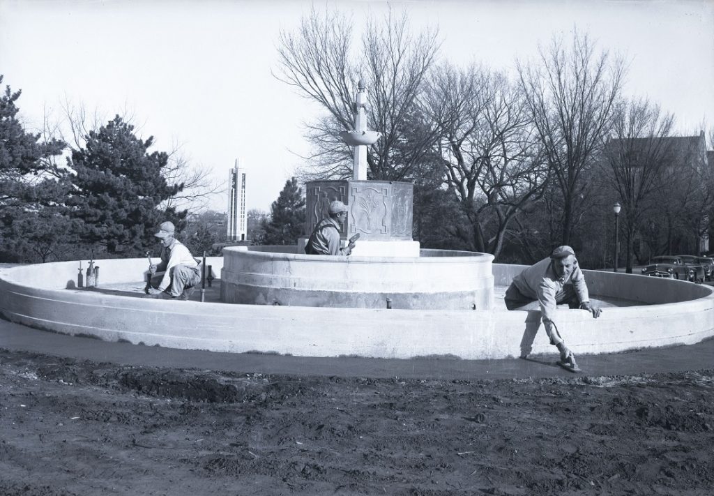 Photograph of workers finishing the Chi Omega fountain, 1955