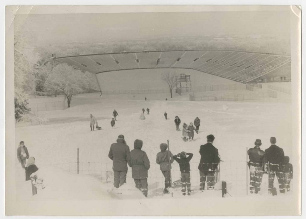 Photograph of people sledding toward Memorial Stadium, 1950s