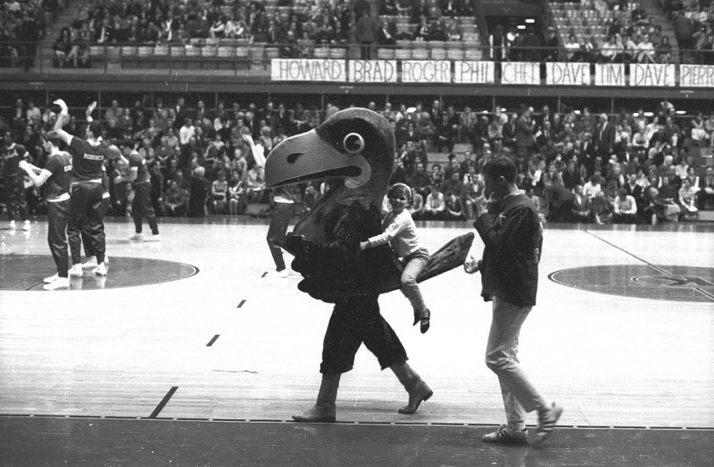 Photograph of Big Jay with a girl riding on his tail, 1970