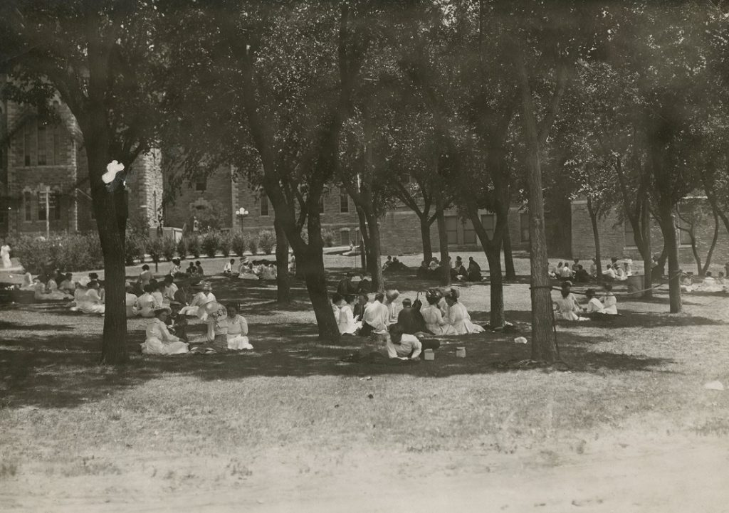 Photograph of students on the lawn in front of Old Fraser Hall, 1900s