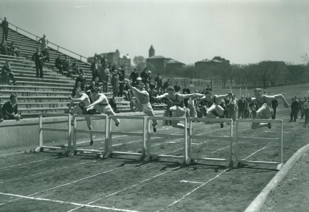 Photograph of six athletes running the hurdles at the Kansas Relays, 1936