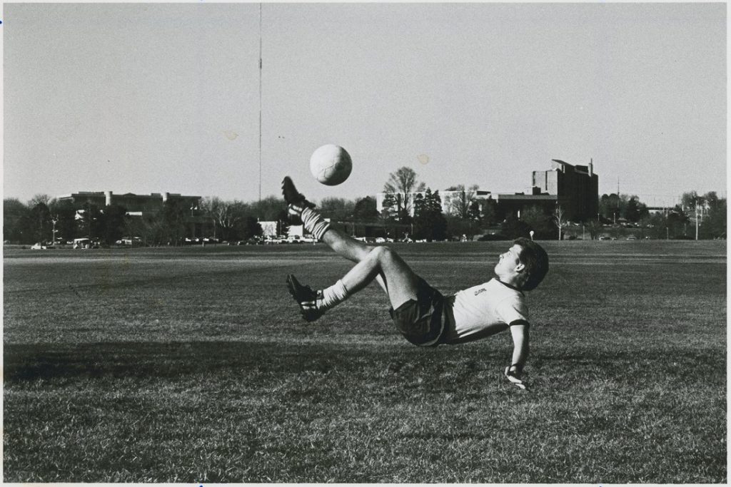 Photograph of a KU soccer player kicking a ball, 1986-1987