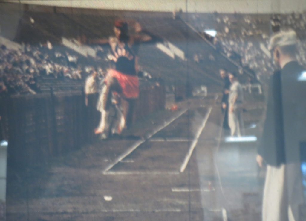 Film still of Wilt Chamberlain in the triple jump event at the Kansas Relays, 1957