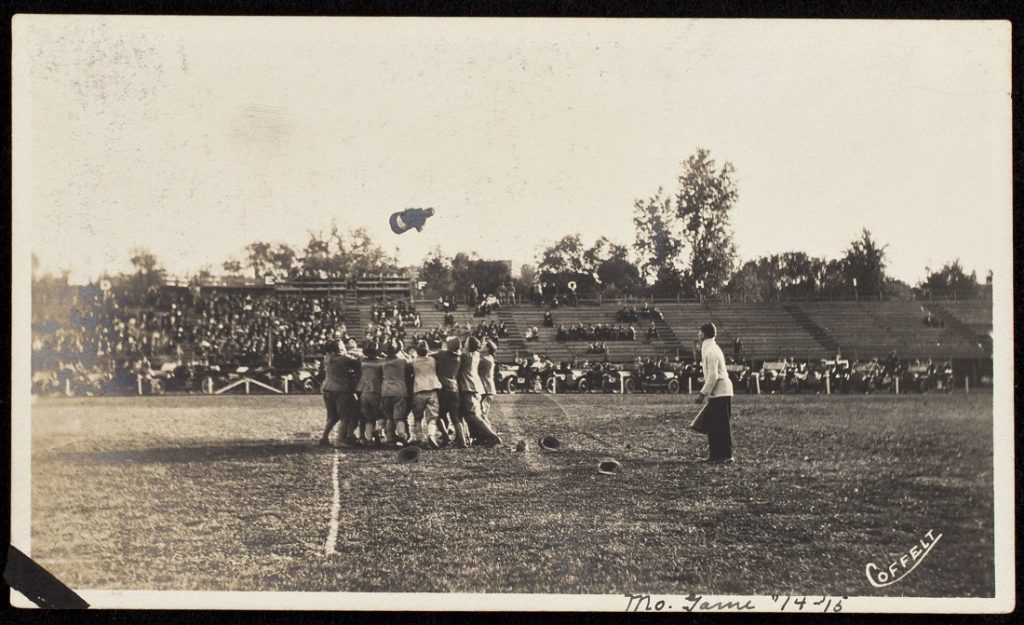 Photograph of a group of men tossing a freshman caught without his cap, 1914