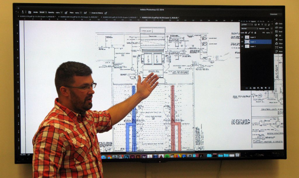 Consultant discussing architectural drawings of Spencer Library's ductwork