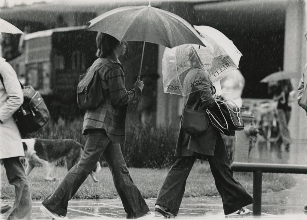 Photograph of KU students walking in the rain, 1976-1977