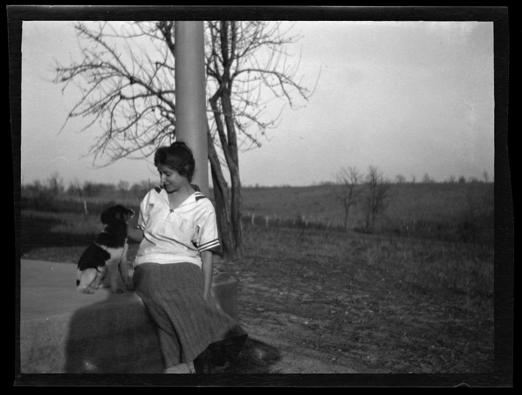 Photograph of a KU student with her dog, 1911