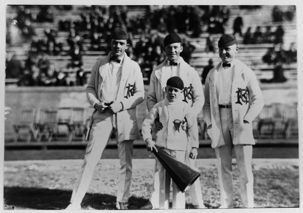 Photograph of three KU cheerleaders with a young boy, 1922-1923