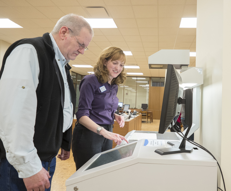 Head of Public Services Caitlin Donnelly Klepper assisting a researcher with the overhead scanner in the Reading Room at Spencer Research Library