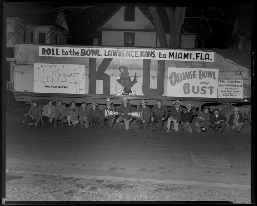 KU football fans kneeling in front of a decorated truck, 1947-1948