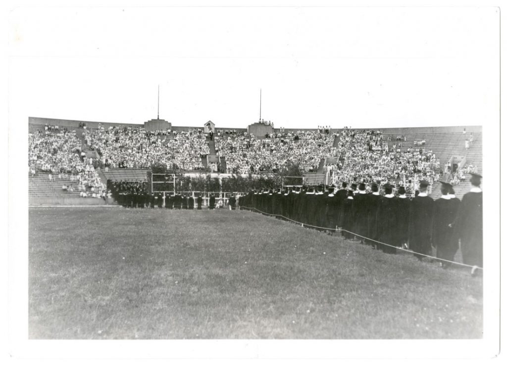 Photograph of KU graduates walking in Memorial Stadium for Commencement, 1933