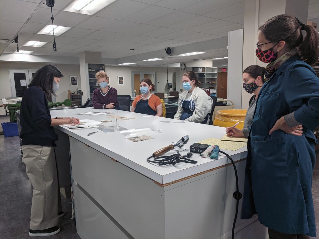 Visiting conservator Minah Song demonstrates the use of pre-coated repair tissues for Conservation Services staff and student employees. Kenneth Spencer Research Library, The University of Kansas.
