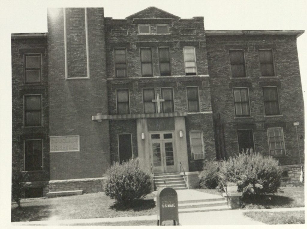 Black-and-white photograph of a large, three-story brick building.