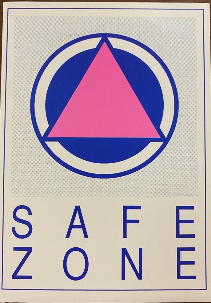 Blue text that says "Safe Zone" on white paper. There is also a pink triangle centered in a blue circle.