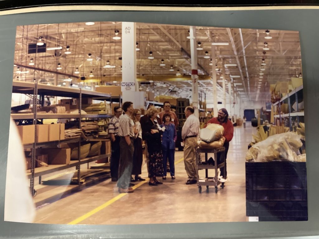 Group of people standing in a large warehouse.