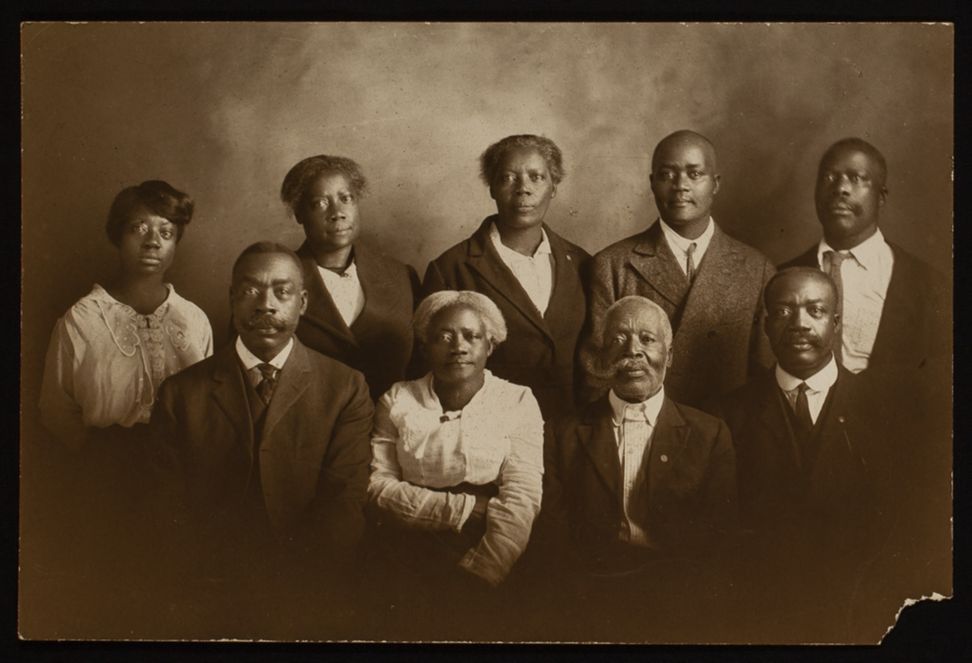 Sepia-toned photograph of nine adults.