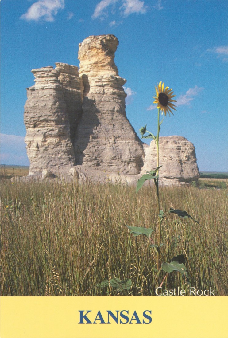 Color postcard of a large rock formation surrounded by prairie grasses.