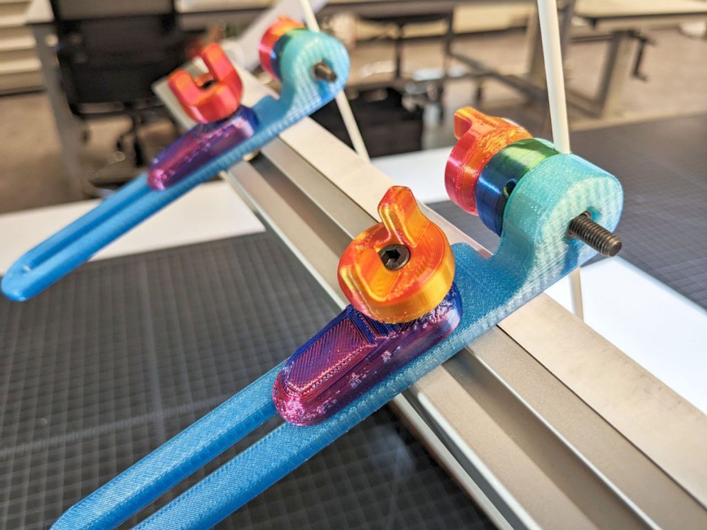 Close up image of colorful 3D printed clamps on an adjustable book cradle.