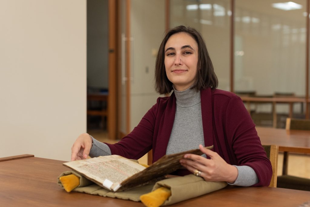 Special Collections Curator Eve Wolynes in the reading room of Spencer Research Library with MS E256