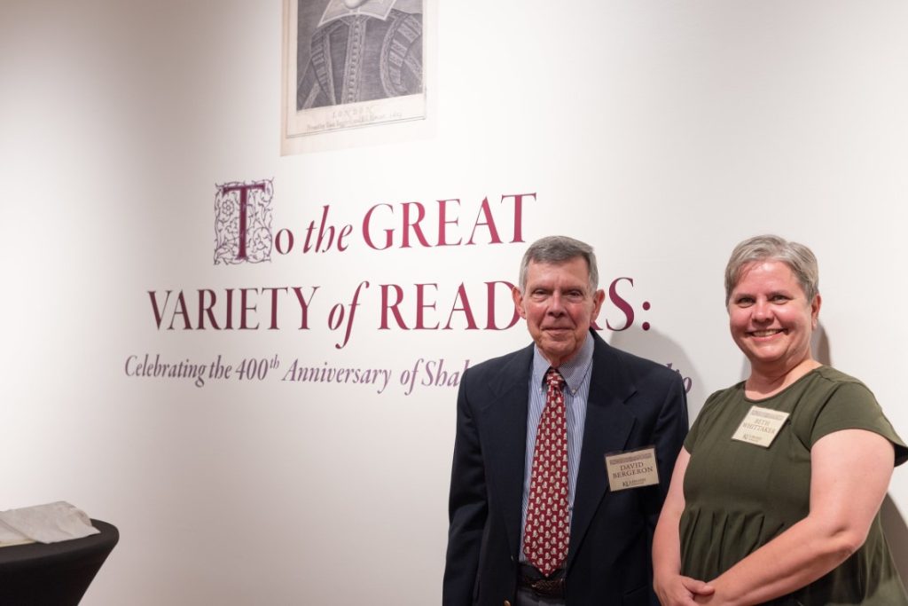 Two people standing near the Shakespeare First Folio title graphic.