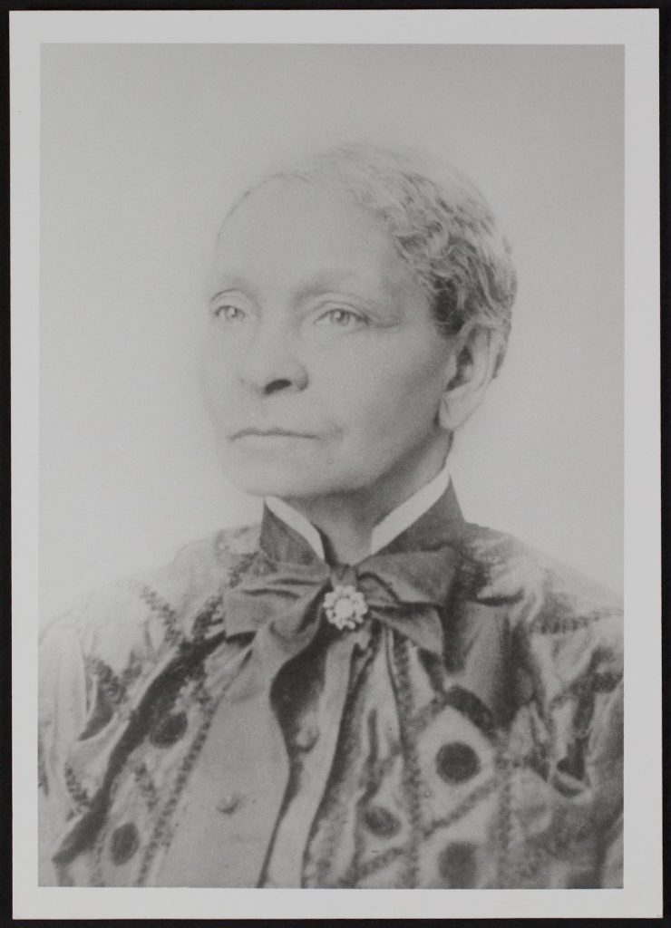 Black-and-white headshot photograph of an older African American woman in a fancy outfit.