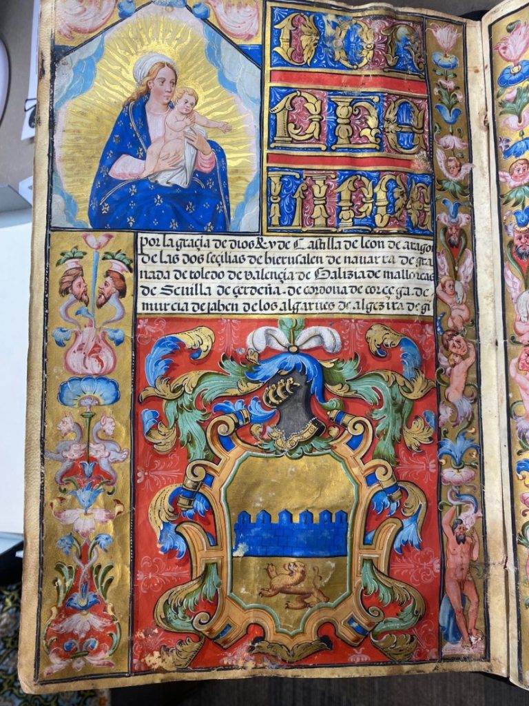Colorful illuminated manuscript page with a block of text in the middle, and illustration of Mary and baby Jesus in the upper left corner, and a large family crest at the bottom.