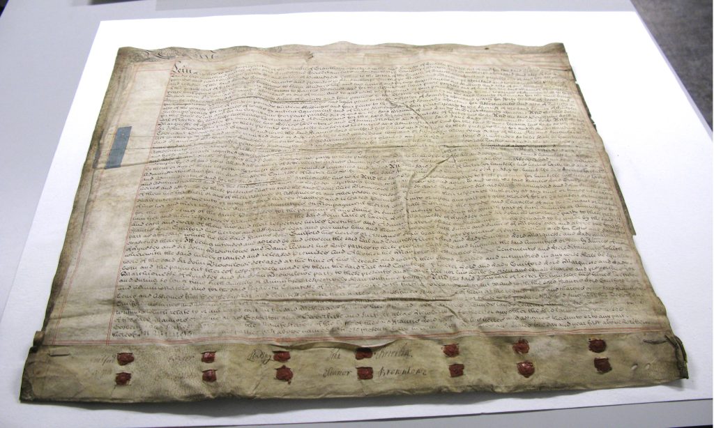 Group of parchment documents affixed to one another with fourteen wax seals at the bottom edge.