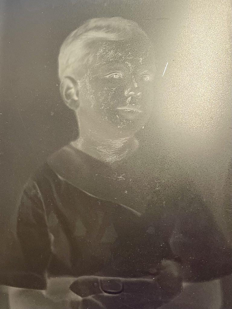 Glass plate negative with scratches on surface.