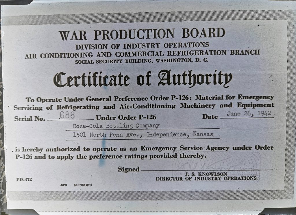 Plate 5504 (John Gooldy). A Certificate of Authority issued by the U.S. War Production Board giving the Independence, Kansas Coca-Cola Bottling Company permission to operate during wartime as an emergency vendor for refrigerator/air-conditioning repair. Hannah Scott Studio Collection, Kansas Collection, University of Kansas Libraries.