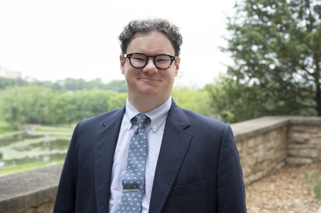 Headshot photograph of a man with glasses.