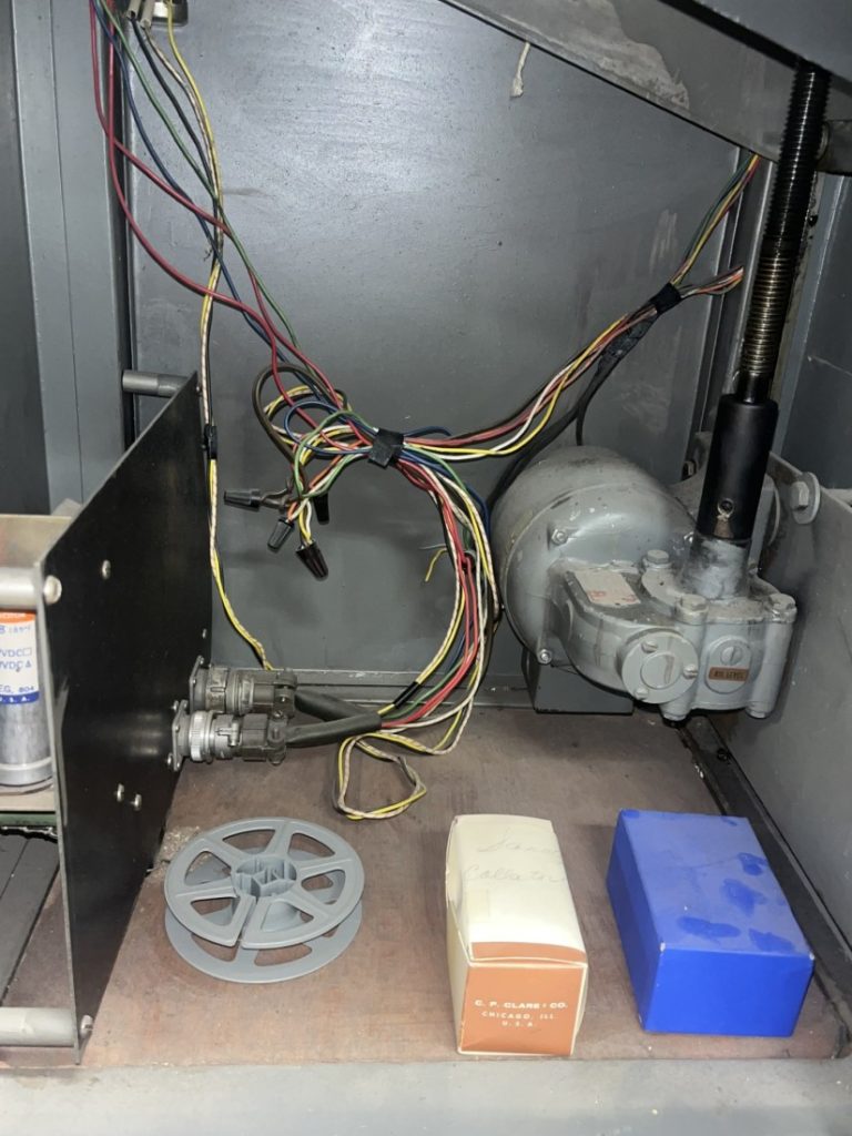 Color photograph of multicolored wires bundled together in a larger metal box.