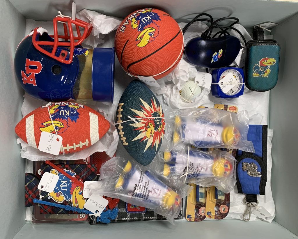 An assortment of off-gassing plastic artifacts are pictured together in a box before rehousing.