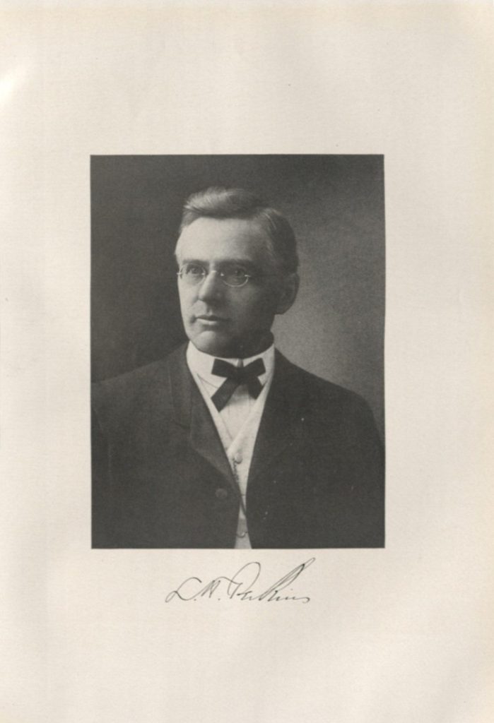 Black-and-white headshot portrait of a white man wearing glasses.