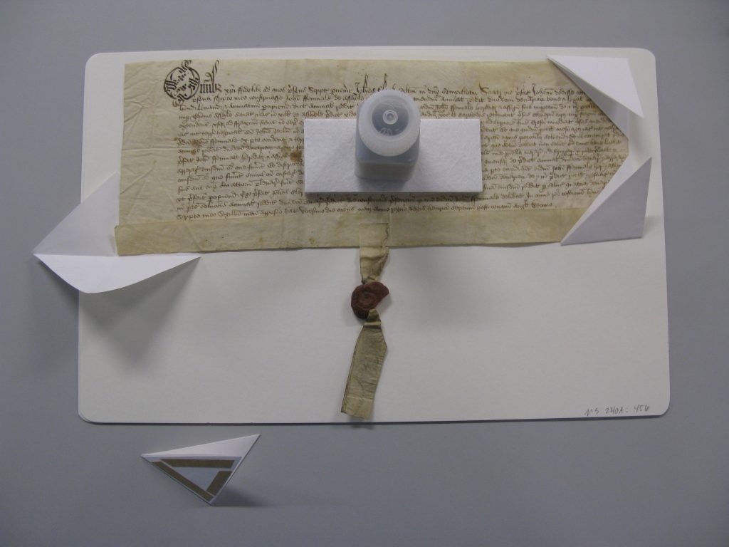 Parchment document attached to a support board with paper corners that can be opened to easily remove the document.