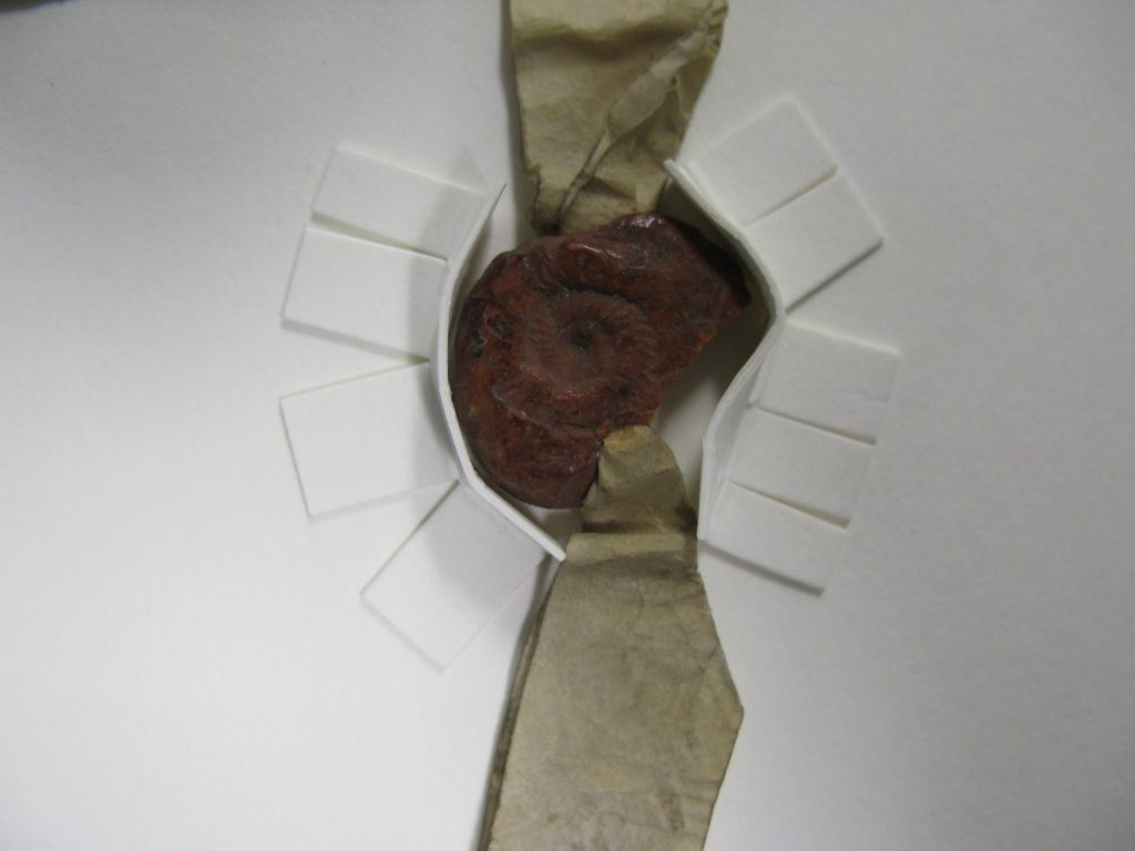 Wax seal on strip of parchment, supported by matboard bumpers.