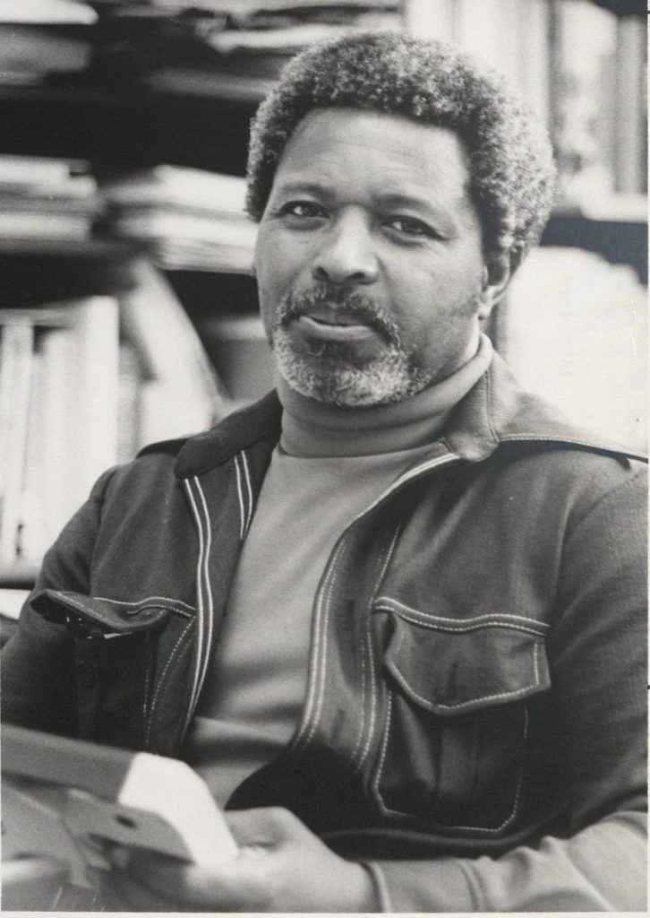 Photograph of Sam Adams in his KU office, late 1970s, early 1980s.