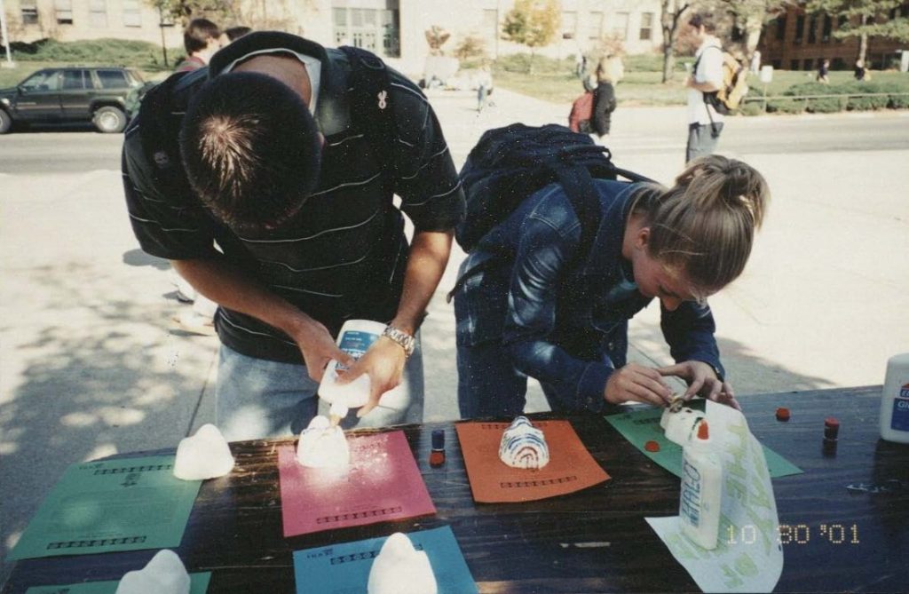 Photograph of two students using glue to make calaveras.